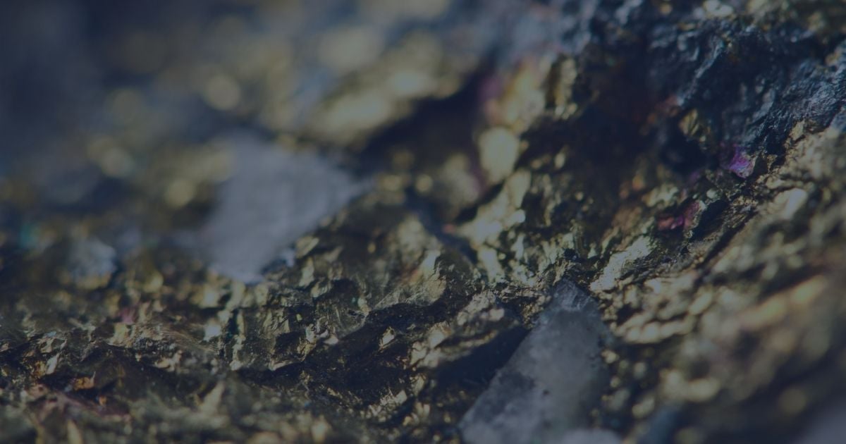 Close-up of a mineral-rich rock surface containing visible gold and quartz veins