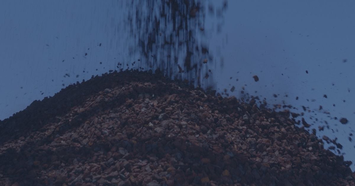 Crushed ore being discharged in a stockpile during material handling at a mining facility