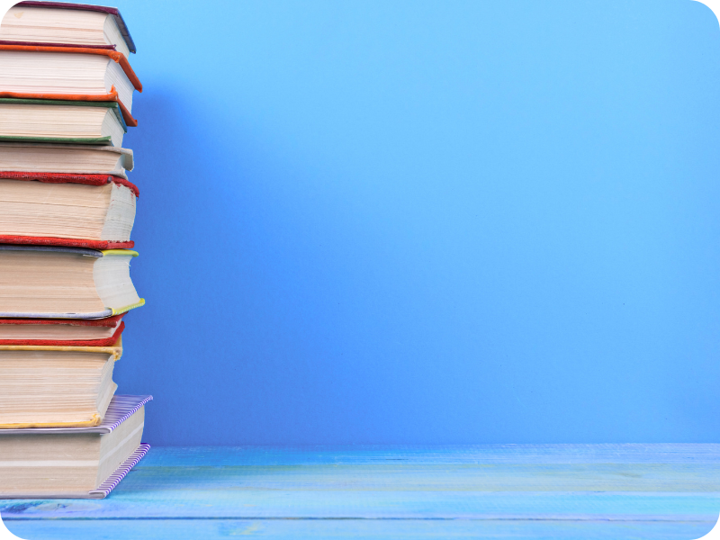 Stack of hardcover books against a blue background, representing documented case studies and project insights