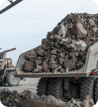 Large haul truck unloading ore onto a mining site stockpile.