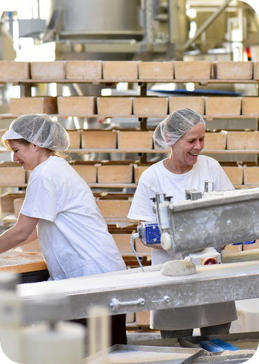 Food production workers operating on a live manufacturing line, highlighting the importance of real-time monitoring and early downtime detection.