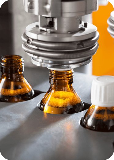 Automated bottling machine sealing amber glass bottles in a pharmaceutical or food production facility